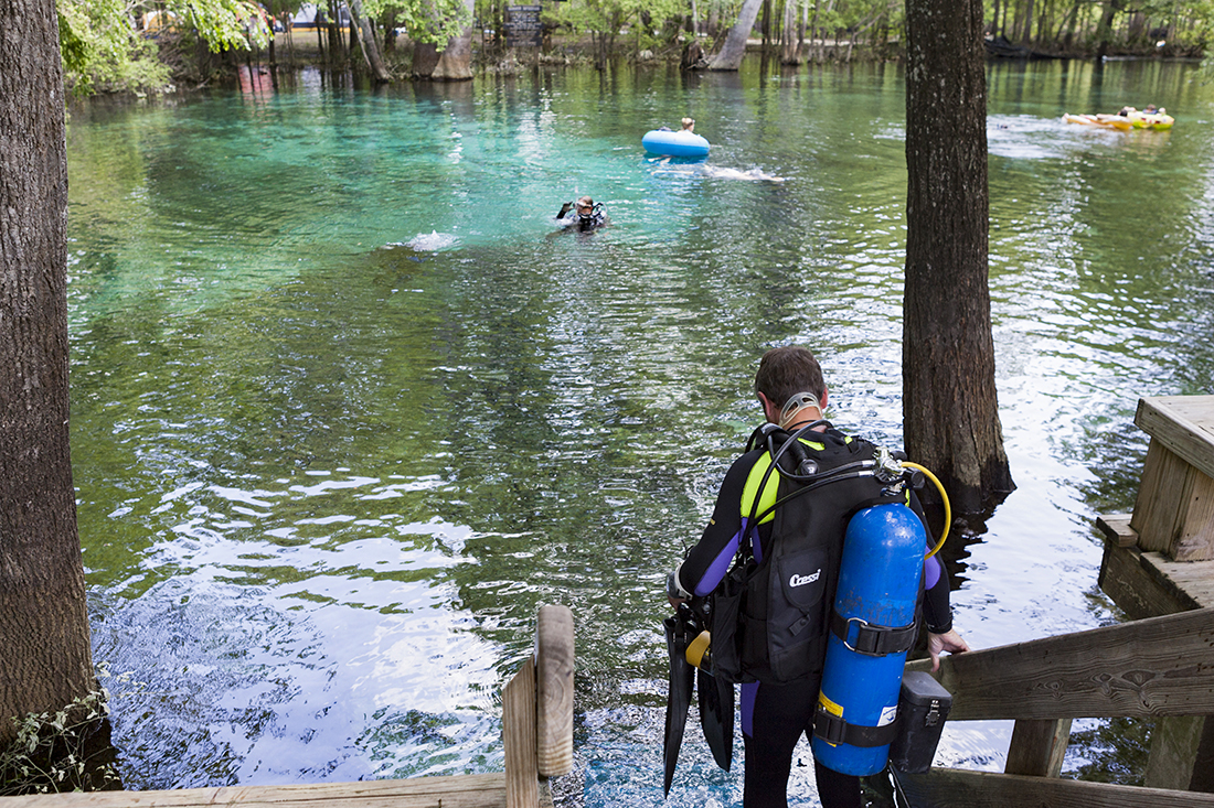 A recreational diver utilizes the stairs provided at Ginnie Springs main spring basin to enter the water for a dive.