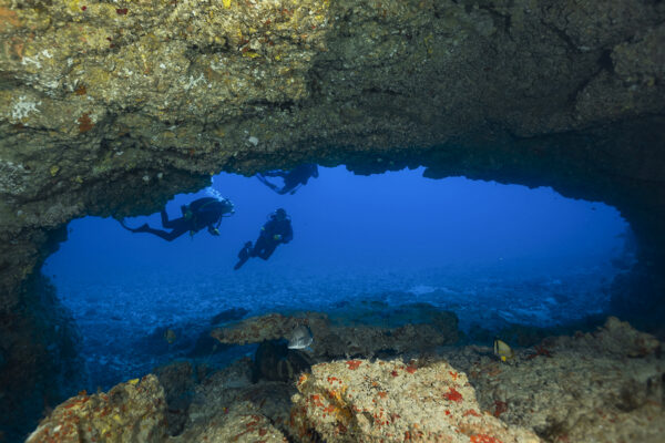 Divers framed by the main entrance of the Hole-in-the-wall off Jupiter Florida.